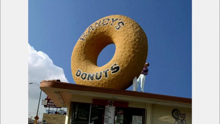 trying to eat his way  through this enormous plaster donut.